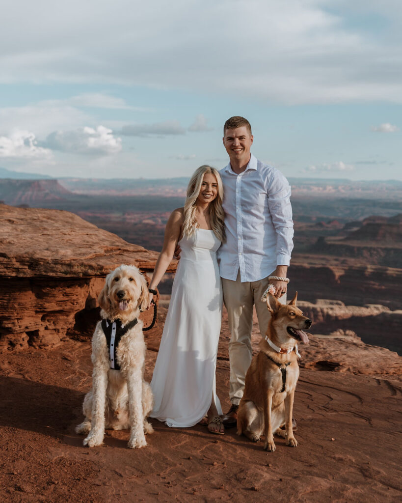 couple poses with dogs at Moab elopement