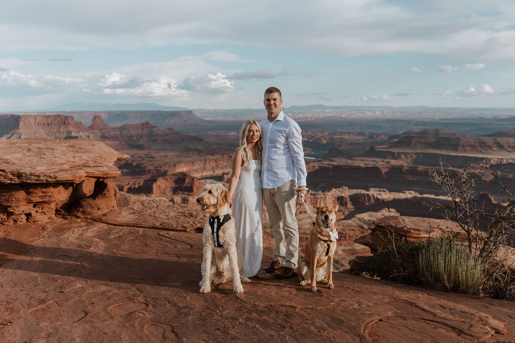 couple poses with dogs at Moab elopement