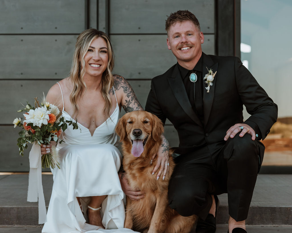 couple poses together with dog