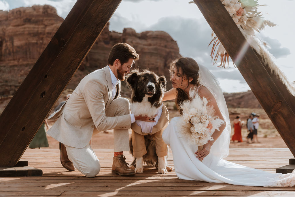 couple poses with dog at Moab elopement