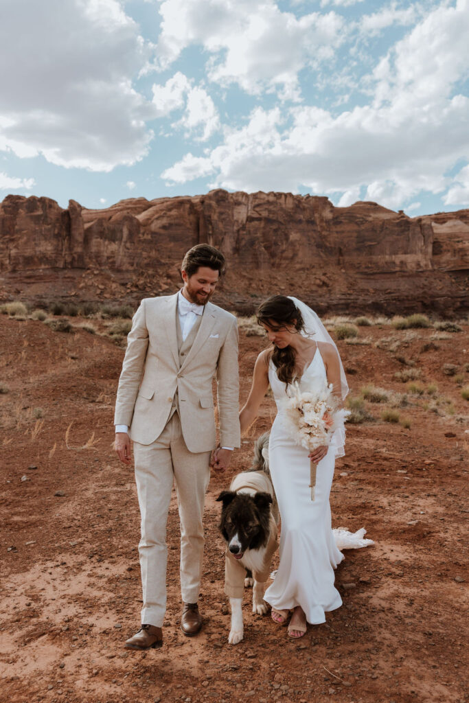 couple walks dog at Moab elopement