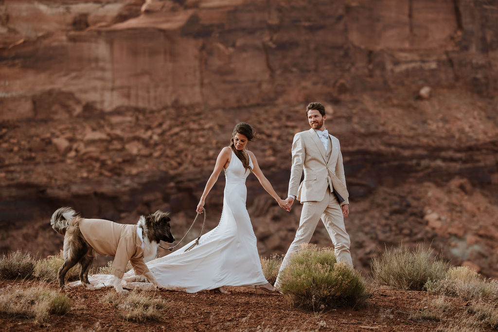 couple walks dog at Moab elopement