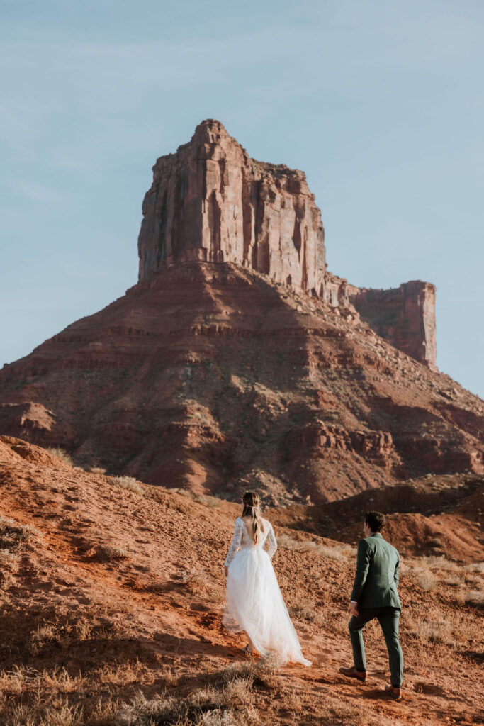 Couple walks out of a valley at dessert elopement