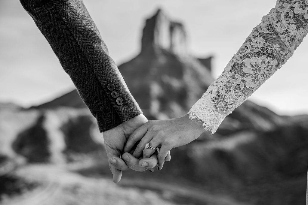 Couple holds hands at dessert elopement