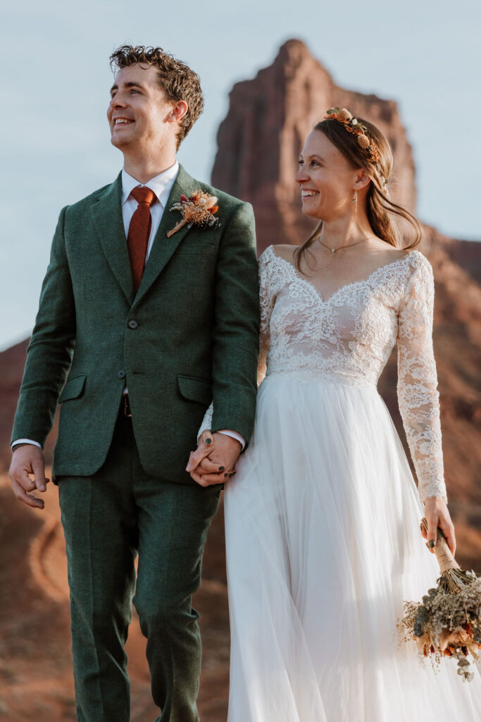 Couple walks hand in hand during couples photos at Castle Valley Utah Elopement