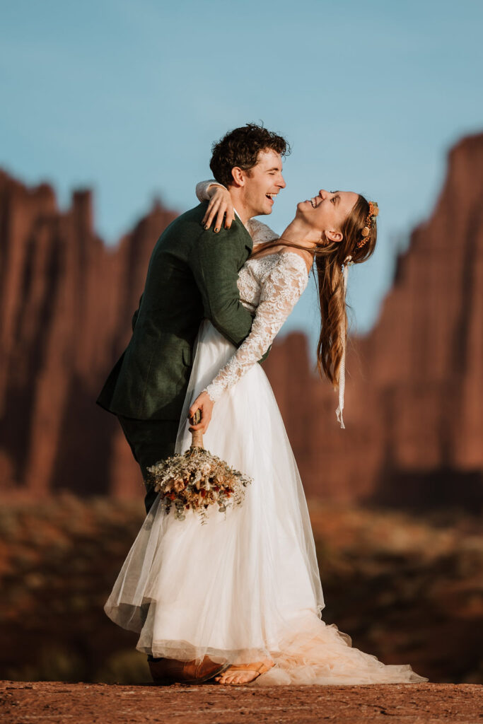 couple laughs together during photos at Castle Valley Utah Elopement