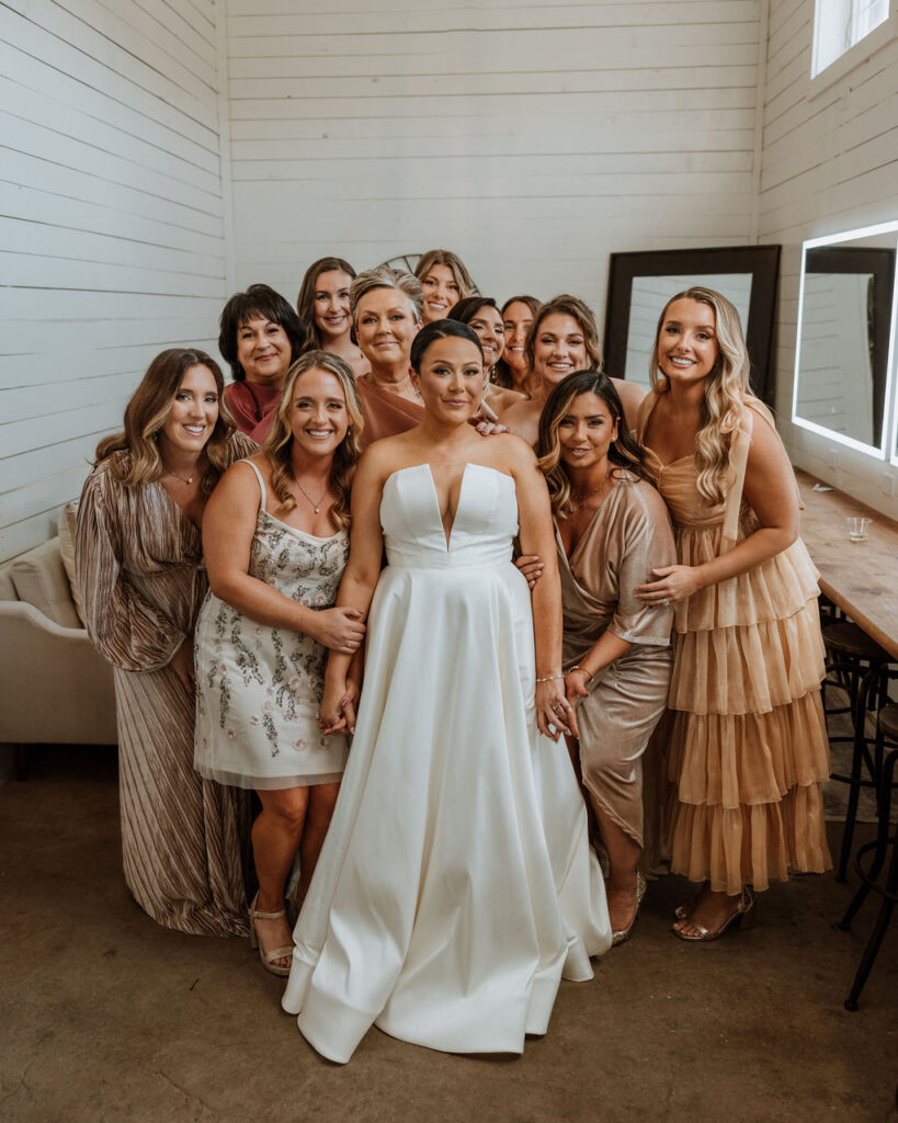 bride poses with bridesmaids in wedding bridal suite