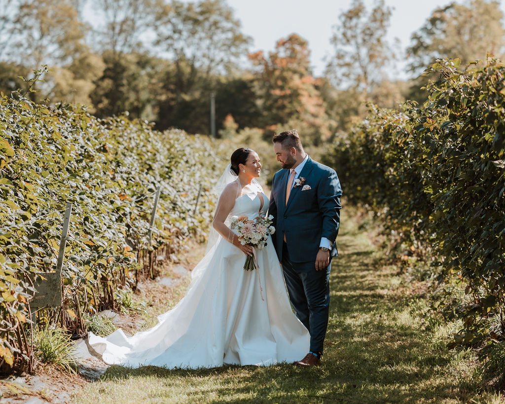 couple stands in vineyard at outdoor wedding venue