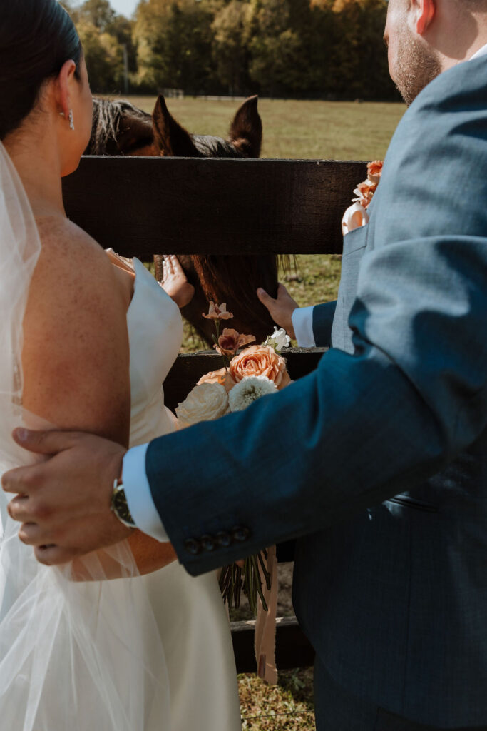 couple pets horse at rustic wedding venue