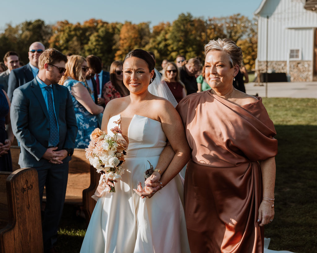 mother of the bride walks the bride down the aisle