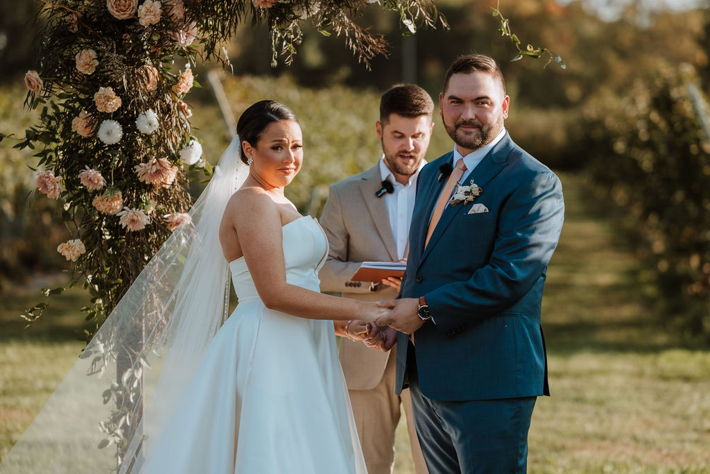 couple looks at guests during wedding ceremony