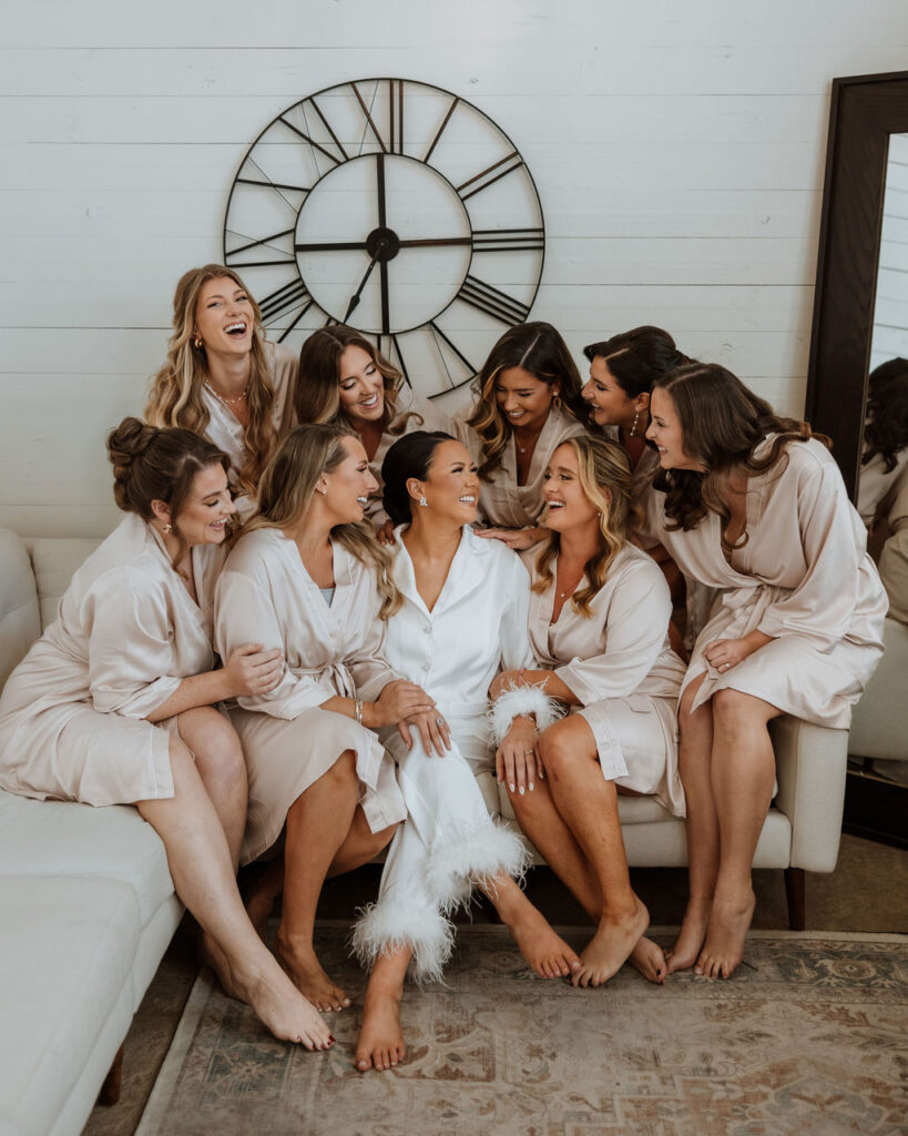 bride poses with bridesmaids in wedding bridal suite