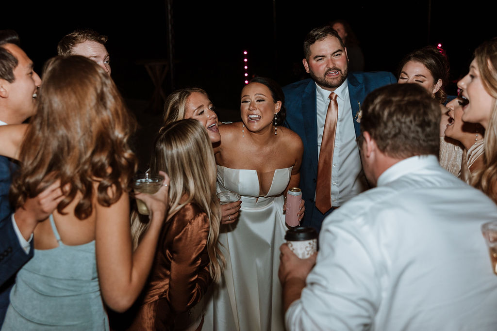 wedding guests dance with bride and groom