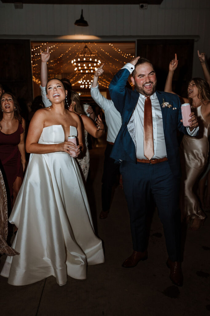 couple dances with guests during wedding reception