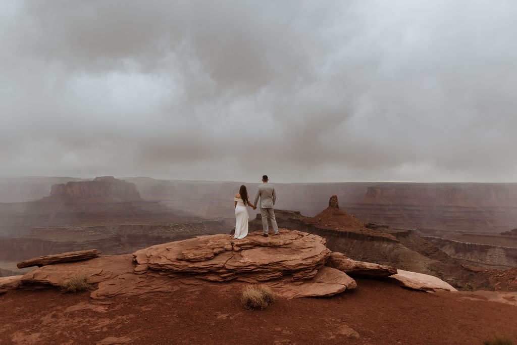 couple stands on overlook at Moab elopement