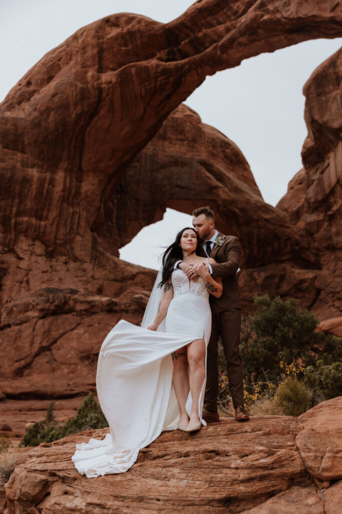 couple embraces at Arches National Park elopement