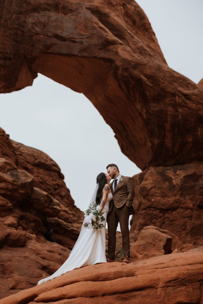 couple kisses at Arches National Park elopement