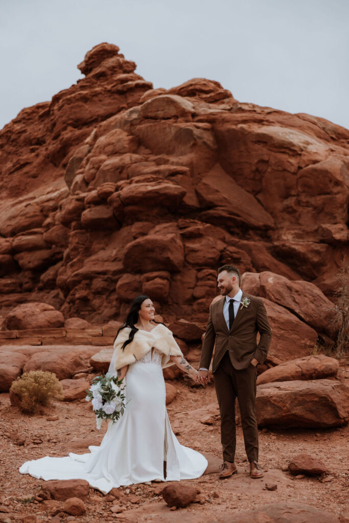 couple holds hands at Arches National Park