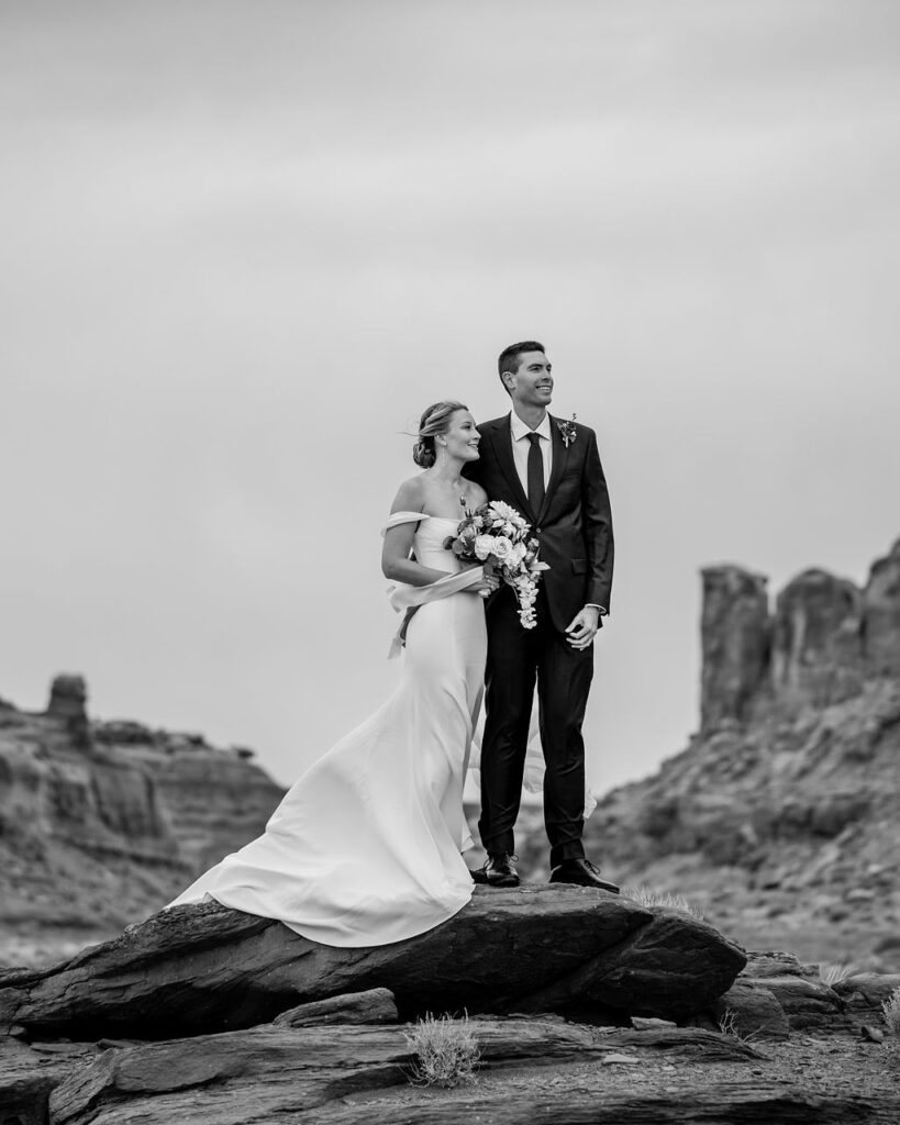 couple stands on red rock at Dead Horse Point State Park