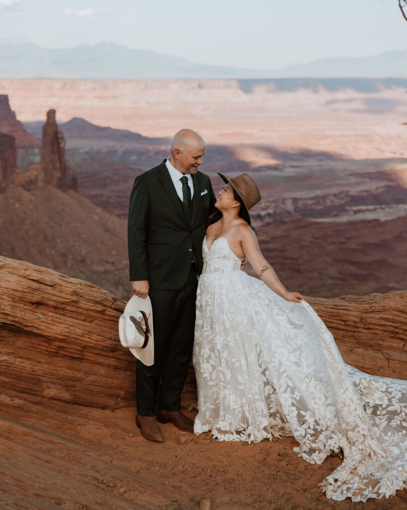 couple stands on cliff edge at canyonlands national park