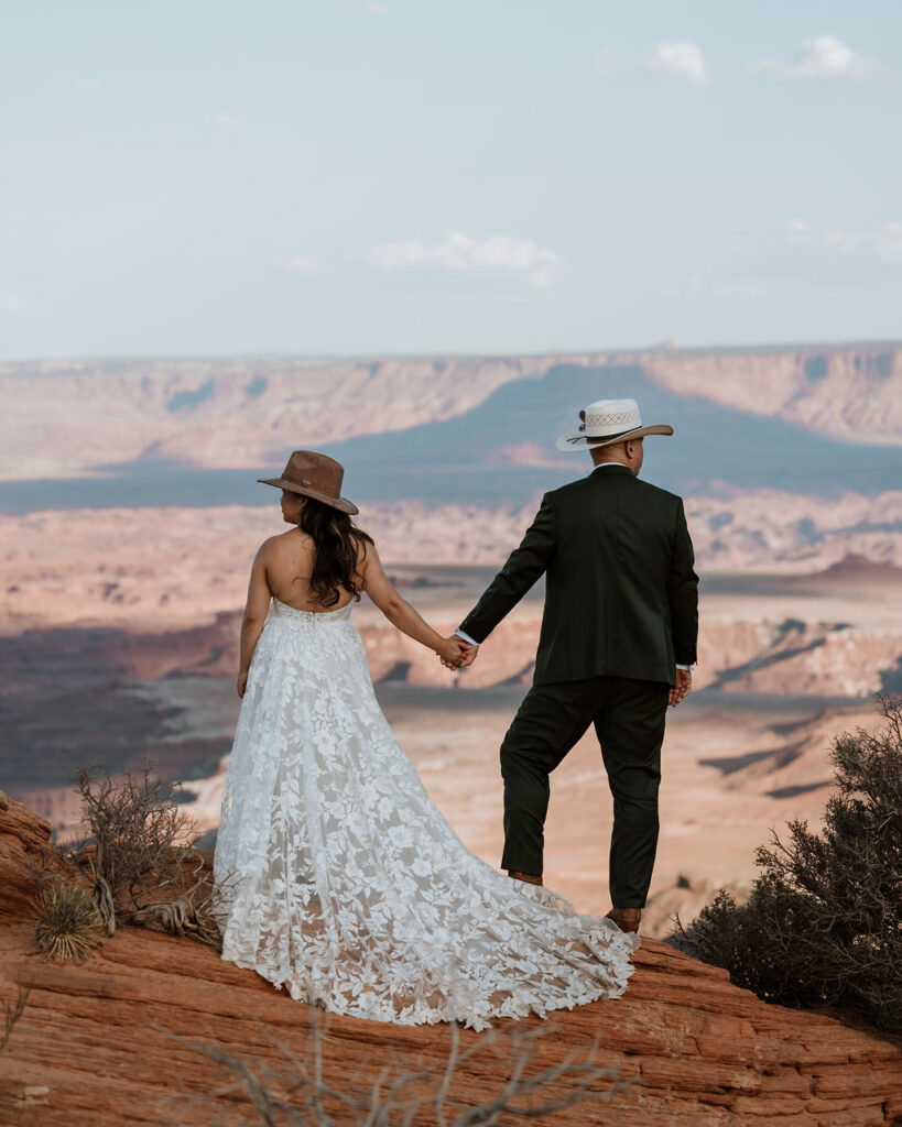 couple stands on cliff edge at canyonlands national park