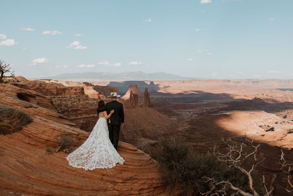 couple stands on cliff edge at canyonlands national park