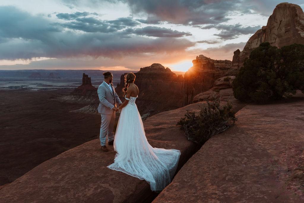 couple holds hands at sunset Canyonlands National Park elopement