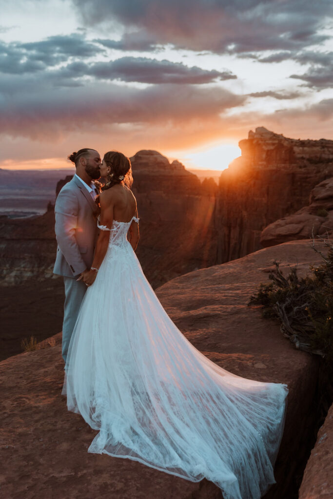 couple kisses at sunset Canyonlands National Park elopement