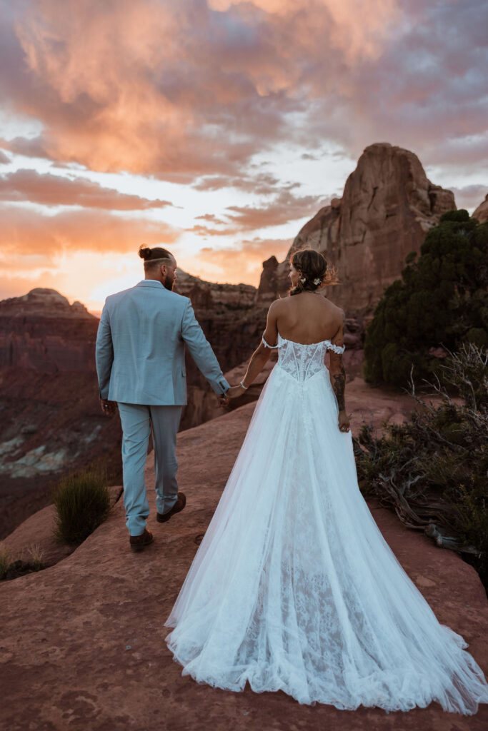 couple holds hands at sunset Canyonlands National Park elopement