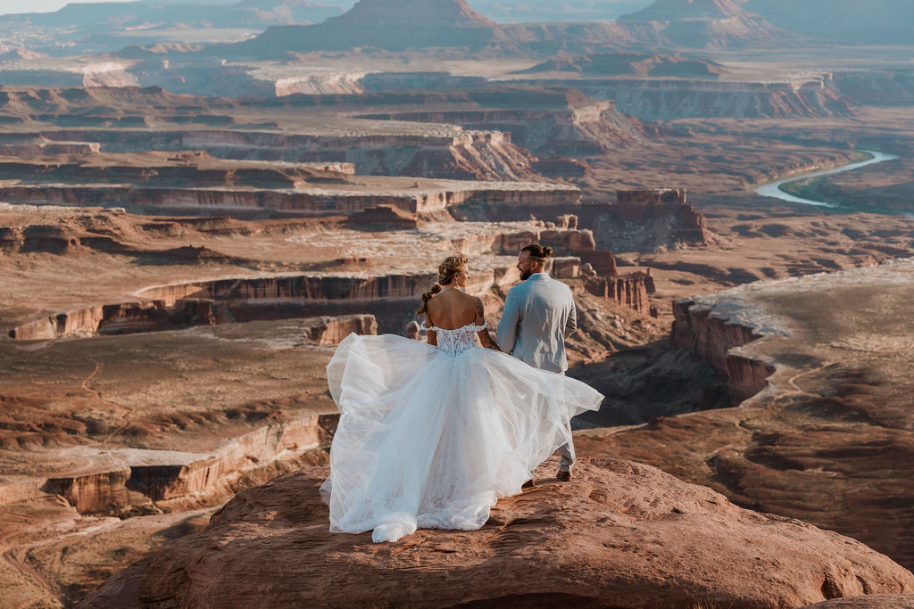 couple stands on cliff edge at Canyonlands National Park elopement