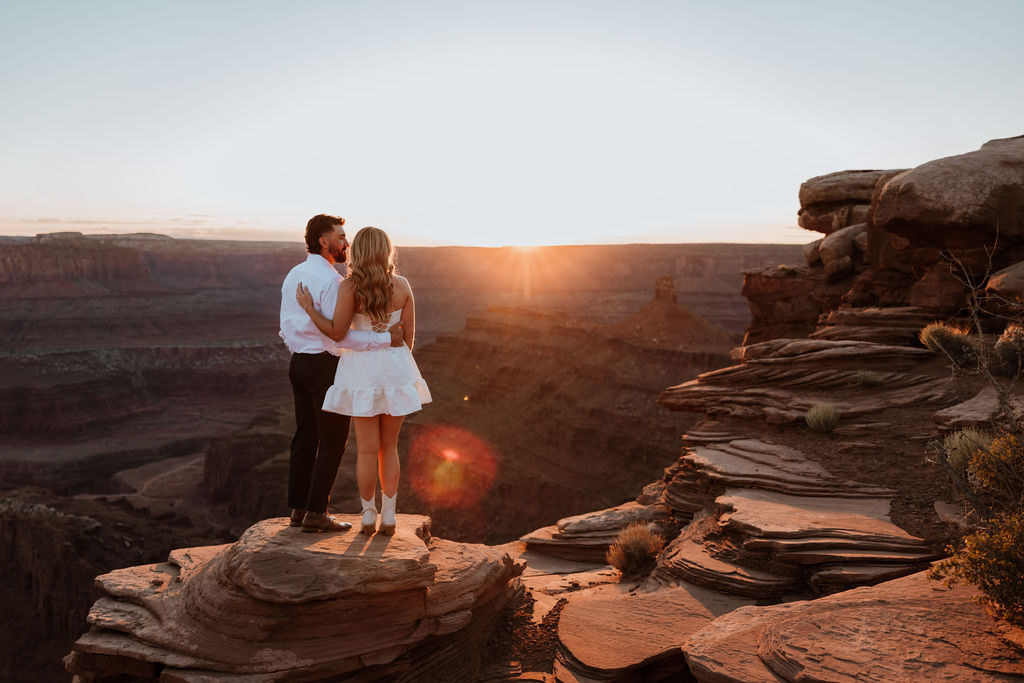 couple embraces on ledge at Dead Horse Point Moab