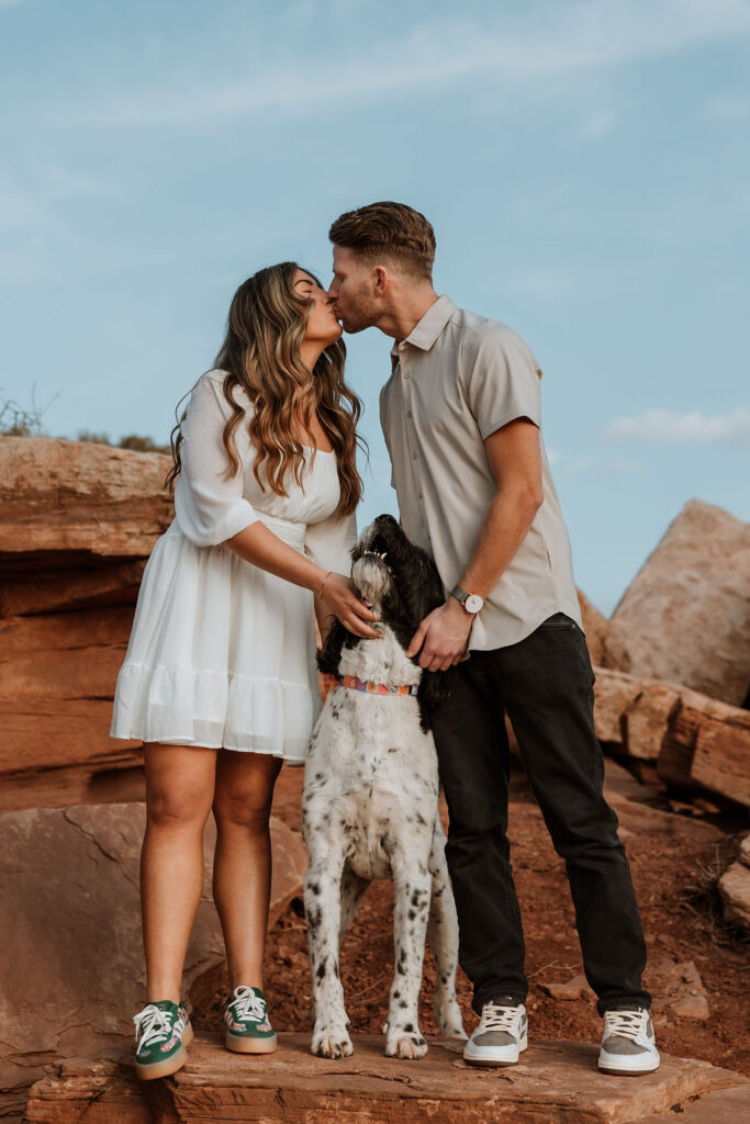 couple kisses with dog at Dead Horse Point 