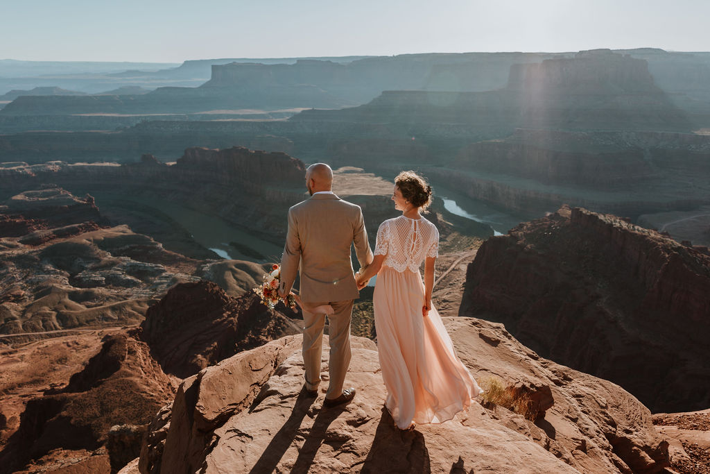 couple holds hands at Dead Horse Point State Park