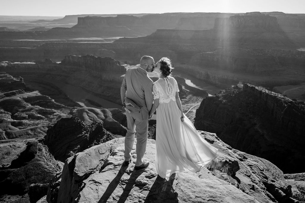 couple kisses on cliff edge at Dead Horse Point State Park