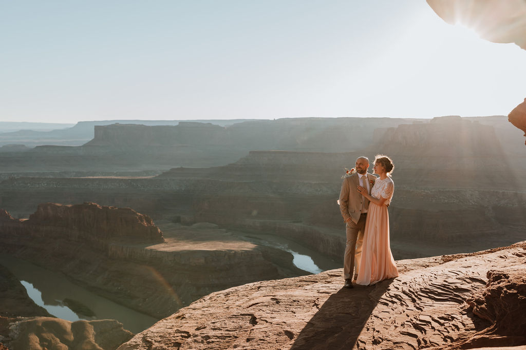 couple embraces on cliff edge at Dead Horse Point State Park