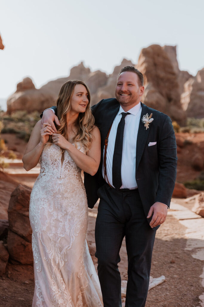 couple holds hands at Arches National Park elopement