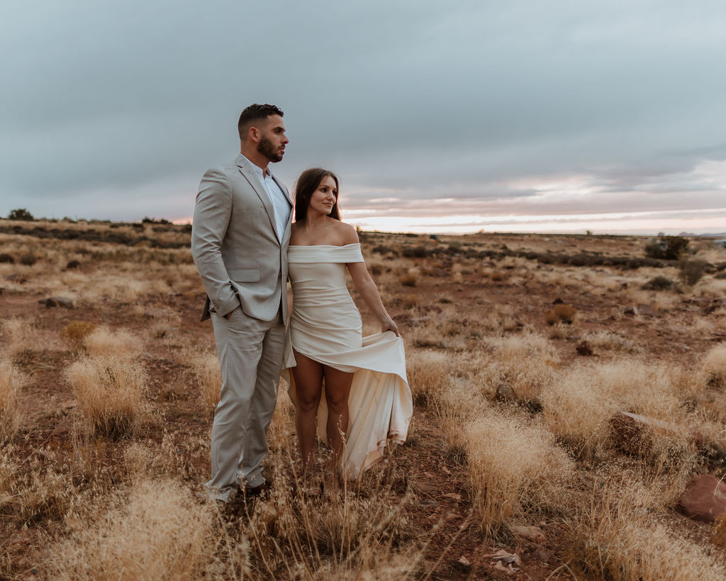 couple posing in field after wedding in moab