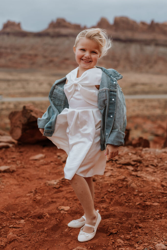 little girl posing in front of rocky landscape in moab