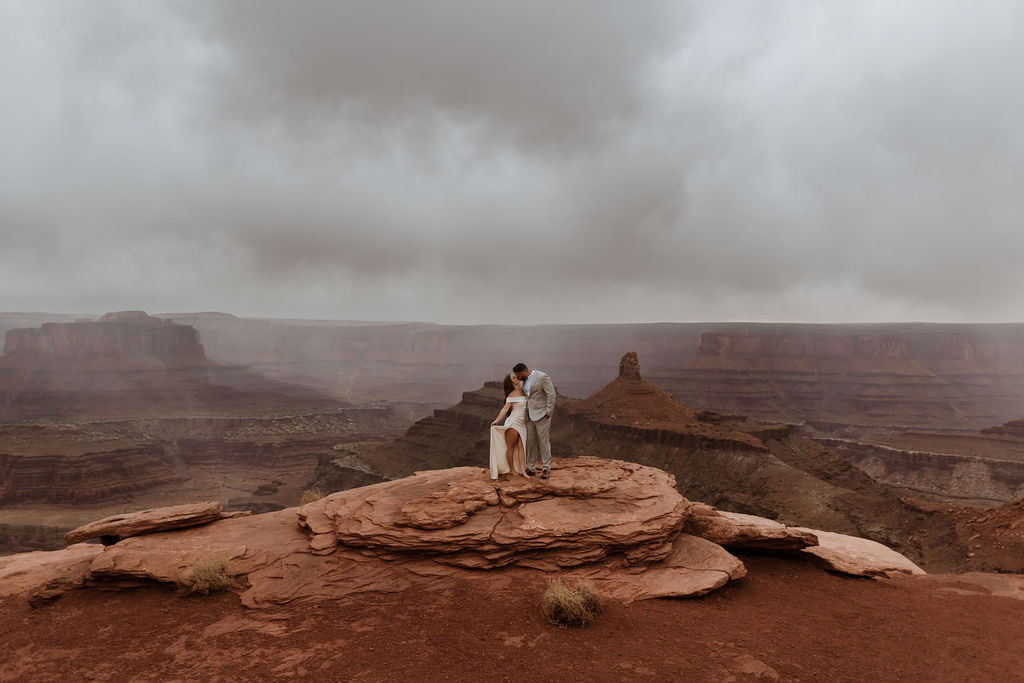 Couple kisses on Canyon overlook after wedding in moab