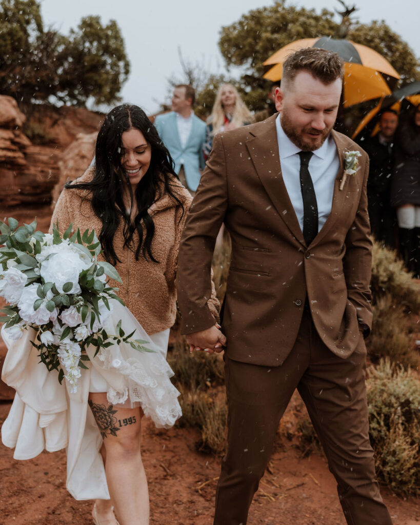 couple walking in rain on wedding day