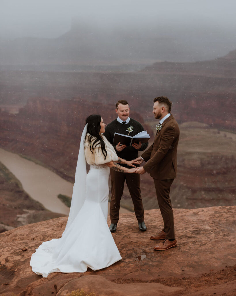 couple holds hands through ceremony during wedding in moab