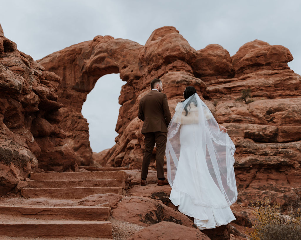 Couple stands at Moab arches for portraits