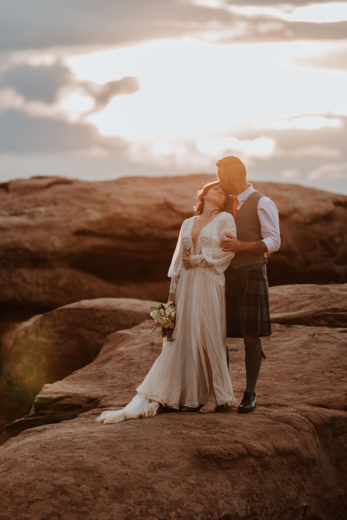 couple embrace on rocky landscape