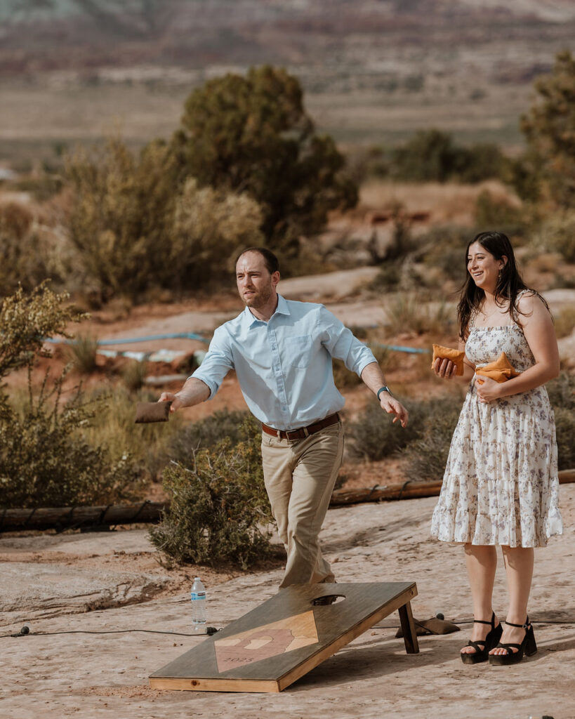 guests play cornhole during reception at under canvas moab