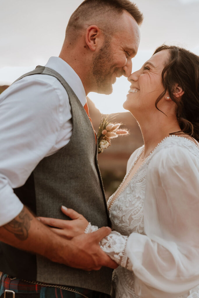 couple embrace during sunset under canvas moab