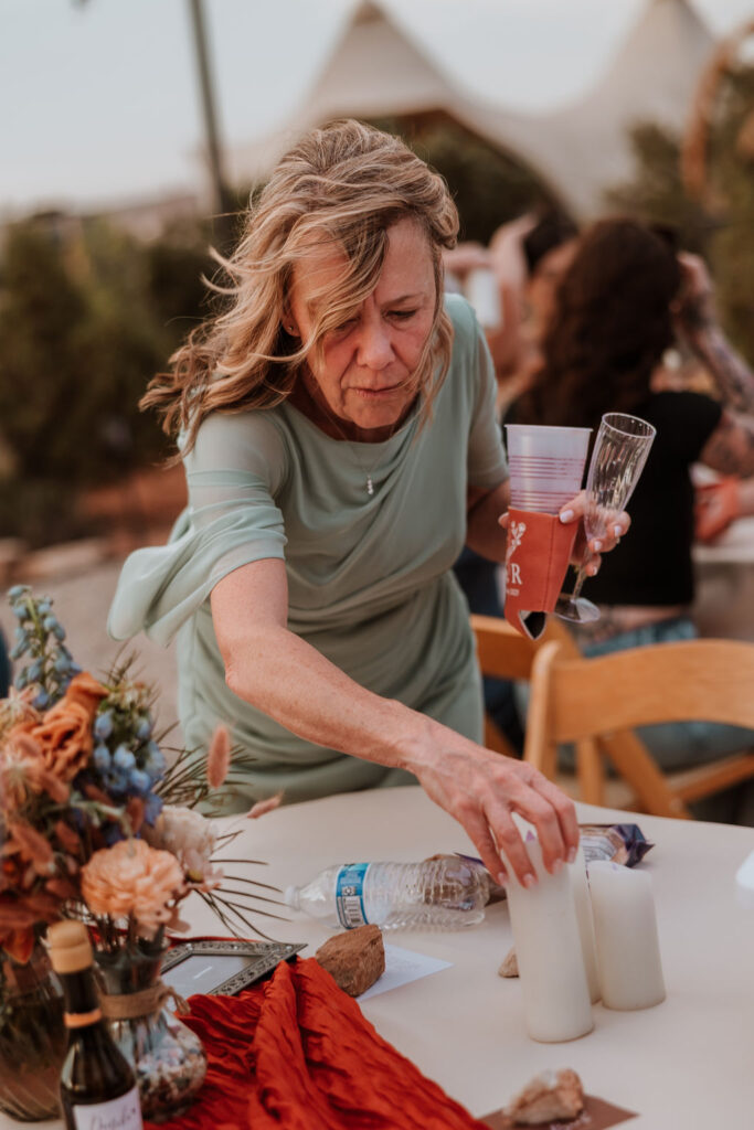woman picking up candles and drinks after falling from the wind