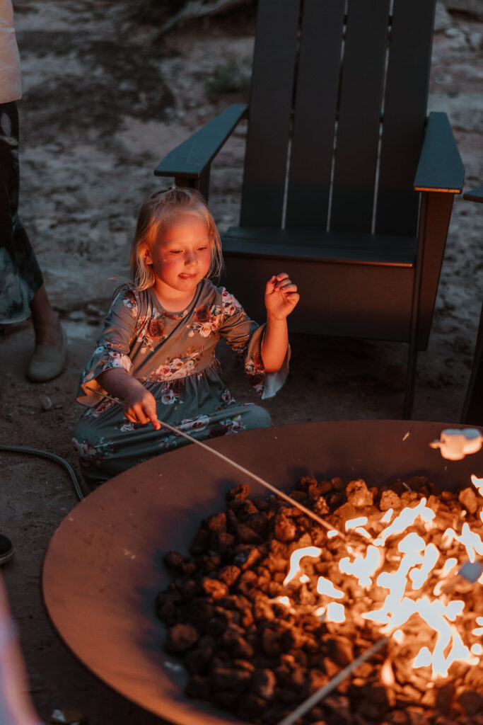 little girl roasting marshmallows in firepit