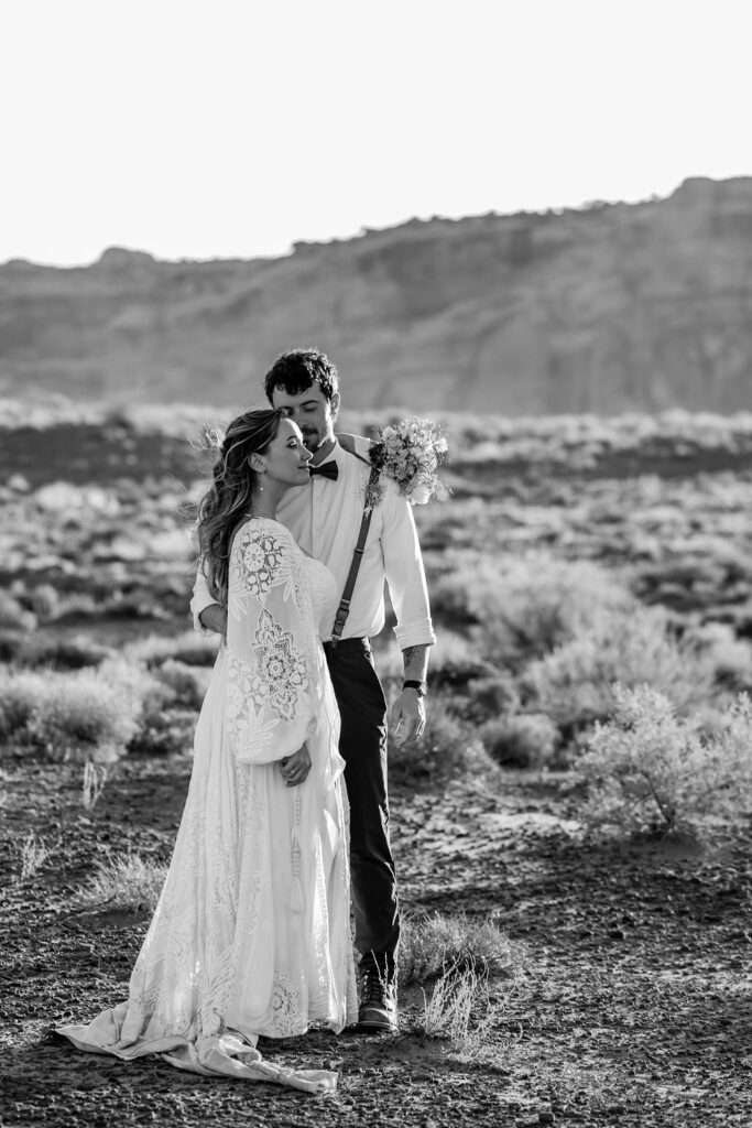 groom kisses bride's forehead during sunset photos