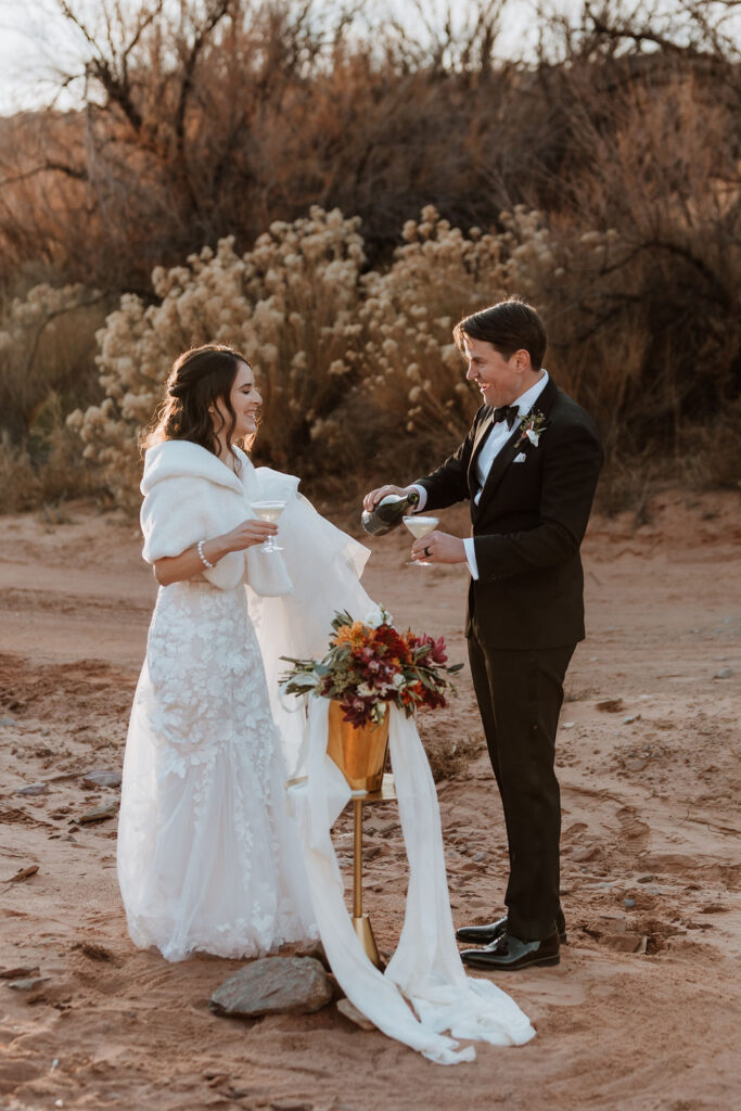 couple pouring champagne to celebrate their wedding in moab