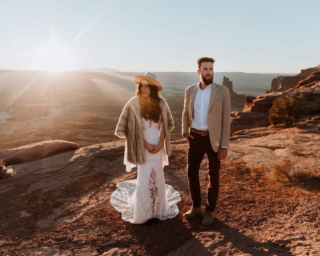 couple posing on canyon overlook at sunset